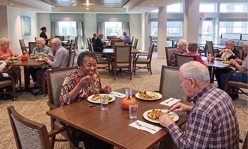 A group of people are sitting around a table in a restaurant, enjoying a meal together. They are smiling and laughing, creating a warm and friendly atmosphere. The table is set with various dishes, including bowls, cups, and wine glasses. There are also utensils such as forks and knives placed on the table. The people are seated on chairs, with some of them wearing ties. The scene captures a moment of shared happiness and camaraderie among the group. AI generated content